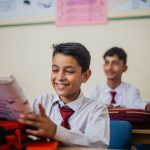 a group of young men sitting at desks in a classroom